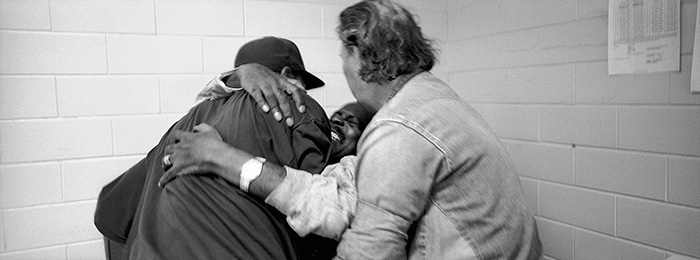 Hospice volunteer Harun Sharif, left, and inmate Calvin Dumas, right, help lift George Alexander out of bed. Sharif and Dumas were helping Alexander get ready for a trip to the hospital in Baton Rouge, LA.